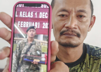 ROSAFINDI Tambi Chik menunjukkan gambar Muhammad Amirul Raziq yang kritikal dan kini dirawat di Hospital Temerloh, Pahang.