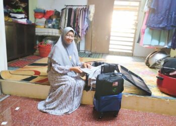 NORHUDA Hassan mengemas pakaian dan peralatan sebelum berangkat ke tanah suci Mekah di Felda Kota Gelanggi Empat, Jerantut, Pahang. - HARIS FADILAH AHMAD
