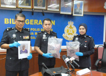 Ahmad Abu Bakar (tengah) menunjukkan sebahagian daripada pil ectasy yang dirampas dalam sidang akhbar di IPD Alor Gajah, Melaka. UTUSAN/AMRAN MULUP