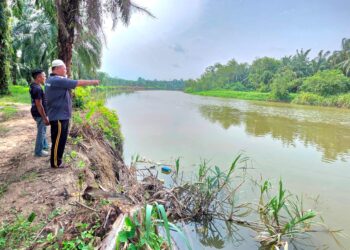 NELAYAN menunjukkan lokasi kemunculan buaya di Sungai Kinta di Kampung Permatang  Pelanduk di Pasir Salak semalam. - UTUSAN/AIN SAFRE BIDIN