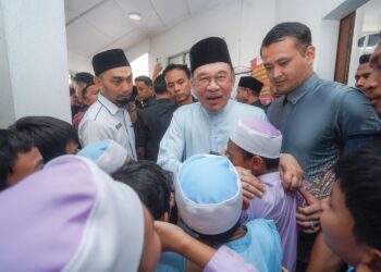 ANWAR Ibrahim menyantuni kanak-kanak selepas menunaikan solat Jumaat di Surau Bomba Cyberjaya, semalam. – UTUSAN/FAISOL MUSTAFA
