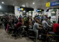 PENUNGGANG motosikal beratur mengisi petrol di sebuah stesen minyak di Karachi, hari ini. - AFP