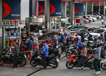 Barisan kenderaan beratur di sebuah stesen minyak ketika harga bahan api meningkat di Quezon City, Metro Manila pada 9 Mac lalu. - AFP.