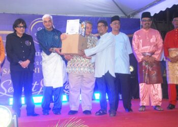 RAIS Yasin menyampaikan sumbangan barangan elektrik kepada salah seorang penerima di Jalan Portugis, Melaka semalam. - UTUSAN/AMRAN MULUP