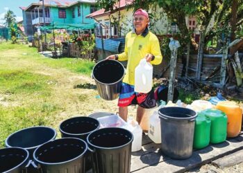 SELAMAT Ikok menunggu giliran bagi mengisi air ke dalam lebih 20 tong miliknya yang dihantar oleh pihak Jabatan Air Negeri Sabah (JANS). - UTUSAN/NASRAWATI SYARIFUDDIN