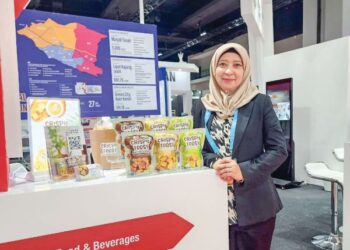 SITI Hafsah Rosli bersama produk makanan ringan Crispy Toast.