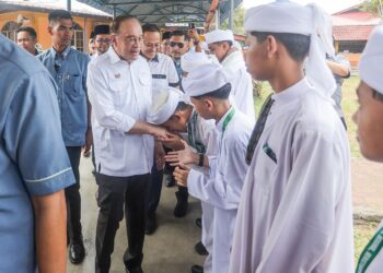 ANWAR Ibrahim (tengah) bersalaman dengan pelajar pada Majlis Ramah Mesra MADANI Pelajar Tahfiz Negeri Terengganu di Sekolah Menengah Imtiyaz Yayasan Terengganu, semalam. – UTUSAN/PUQTRA HAIRRY