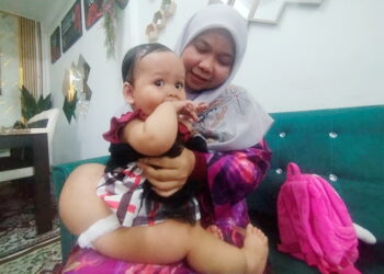 SITI Aisyah Kamarulzaman mendukung Nor Laila Insyirah Muhammad Harith Syahiran yang mengalami masalah kebocoran tulang belakang di Perumahan Taman Seri Intan, Kampung Kayu Kelat, Besut, Terengganu.