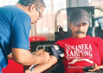 BADRA Isa Ab. Hamid (kanan) menderma darah pada program komuniti di Kampung Bukit Betong di Lipis, Pahang. – UTUSAN/HARIS FADILAH AHMAD