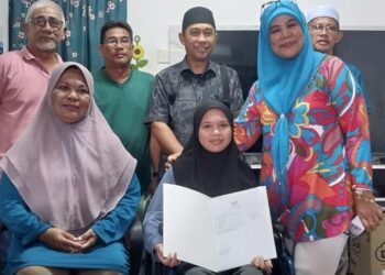 AINA Najwa Nazmi (tengah) menunjukkan keputusan peperiksaan SPM ketika ditemui di Lembah Beriah  di Bagan Serai hari ini. - UTUSAN/WAT KAMAL ABAS
