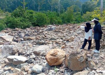 NORHAYATI Musa (kiri) bersama Siti Sabariah Omar menunjukkan aliran air yang kering di kawasan rekreasi Titi Hayun di Yan, Kedah.