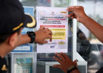 ANGGOTA penguat kuasa KPDN Kelantan menampal pemakluman penjualan RON95 kepada kenderaan asing mulai hari ini di sebuah stesen minyak di Tumpat, Kelantan hari ini.-UTUSAN/KAMARUL BISMI KAMARUZAMAN.
