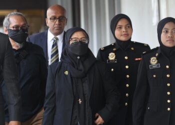 NORHAZNI Mat Sari (tengah) didakwa menerima suapan berjumlah RM21,000 di Mahkamah Sesyen, Kuala Lumpur, hari ini. -UTUSAN/AMIR KHALID