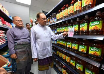 ANWAR Ibrahim bersama Menteri Besar Pahang, Datuk Seri Wan Rosdy Wan Ismail melihat barangan yang dijual selepas merasmikan Madani Mart di Indera Mahkota 8 Kuantan, Pahang semalam. 
– UTUSAN/SHAIKH AHMAD RAZIF