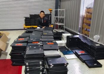 IVAN Khong bersama sebahagian daripada komputer riba yang akan diperiksa secara rapi di pejabat di Cheras.