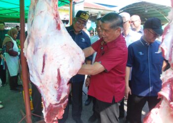 MOHAMAD Sabu melapah daging pada Program Sentuhan Agro Madani Menteri Pertanian dan Keterjaminan Makanan bersama Pemimpin Peladang Negeri Melaka di Dewan Datuk Demang Hussin, Bukit Katil, Melaka hari ini. - UTUSAN/AMRAN MULUP