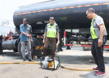 S. JEGAN (kiri) menunjukkan sebahagian daripada peralatan memindahkan minyak yang dirampas susulan serbuan ke atas sebuah lori tangki yang dijadikan stor bergerak untuk menyimpan diesel ketika ditemui di Stor Ekshibit KPDN negeri di Bukit Minyak, Bukit Mertajam, Pulau Pinang.-UTUSAN/DANIAL SAAD