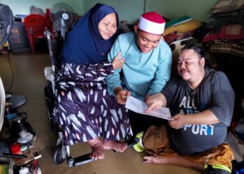 MOHAMF Shaqir Izani Mohamad Shahir (tengah) menunjukkan keputusan cemerlang 9A peperiksaan SPM diperolehnya kepada Mohamad Shahir sambil diperhatikan Salasiah ketika ditemui di rumah mereka di Taman Ria, Port Dickson, hari ini.-UTUSAN/MOHD. SHAHJEHAN MAAMIN.