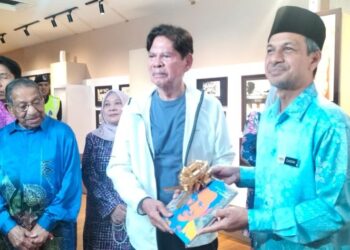 ZAIDIN Mohd. Noor (kanan) menyerahkan cederahati kepada Tun Ramli Ngah Talib sempena Program Kayuhan Jejak Seniman: Rumah Kelahiran P. Ramlee di George Town, Pulau Pinang, hari ini. - UTUSAN/SAFINA RAMLI