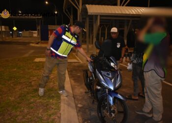 MOHD. Misuari Abdullah (kiri) memeriksa keadaan motosikal semasa operasi rempit di Lapangan Terbang Sultan Ismail Petra, Pengkalan Chepa, Kota Bharu, Kelantan.