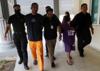 CHE Hisammudin Hassan (dua kanan) bersama rakan diiringi polis semasa menghadiri prosiding perbicaraan di Mahkamah Sesyen Pasir Mas, Kelantan hari ini-UTUSAN/KAMARUL BISMI KAMARUZAMAN.