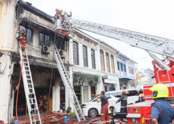 ANGGOTA bomba bertungkus-lumus memadam kebakaran yang berlaku di sebuah rumah kedai dua tingkat yang dijadikan pejabat guaman di Jalan Lebuh King di George Town, Pulau Pinang hari ini.-UTUSAN/DANIAL SAAD