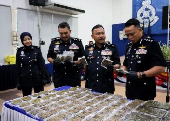 MOHD. Yusoff Mamat (dua kiri) menunjukkan sebahagian ganja yang dirampas dalam serbuan di Rantau Panjang, Kelantan hari ini-UTUSAN/KAMARUL BISMI KAMARUZAMAN.