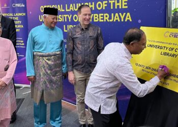 ZAMBRY Abd. Kadir menurunkan tanda tangan atas plak sebagai simbolik Majlis Perasmian Naik Taraf Perpustakaan Digital UoC di Cyberjaya hari ini.