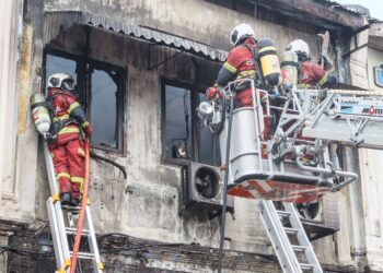 BEBERAPA anggota bomba sedang berusaha untuk melakukan kerja-kerja menyelamat susulan satu kebakaran yang berlaku di Lebuh King, George Town, Pulau Pinang, baru-baru ini.-UTUSAN/DANIAL SAAD