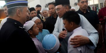 ANWAR Ibrahim menyantuni kanak-kanak ketika hadir menunaikan solat Jumaat di Surau Bomba Cyberjaya. - UTUSAN/FAISOL MUSTAFA