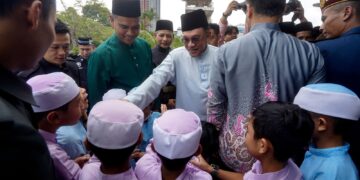ANWAR Ibrahim menyantuni kanak-kanak ketika hadir menunaikan solat Jumaat di Surau Bomba Cyberjaya. - UTUSAN/FAISOL MUSTAFA