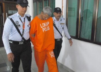 SUSPEK diiringi anggota polis dibawa keluar selepas mendapat perintah reman di Mahkamah Majistret, Alor Gajah, Melaka. - UTUSAN/AMRAN MULUP