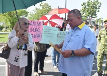 ABU Bakar Hamzah (dua dari kanan) menerima memorandum daripada kumpulan kontraktor yang menganjurkan himpunan aman di hadapan Kompleks Seri Putra, Kangar, Perlis. -UTUSAN/ASYRAF MUHAMMAD