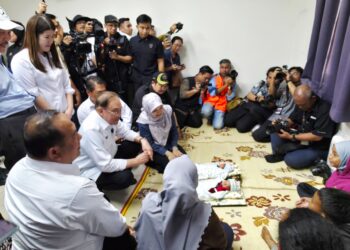 ANWAR Ibrahim menyantuni mangsa kebakaran Kampung Bahagia yang kini ditempatkan di PPS Dewan PPR Taman Batu Sapi, Sandakan, Sabah hari ini.-GAMBAR IHSAN/ JABATAN KETUA MENTERI SABAH