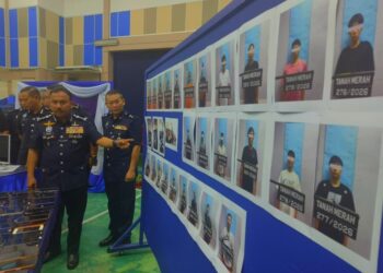 MOHD. Yusoff Mamat (kiri) menunjukkan individu yang ditangkap berkait kes ‘love scam’ dalam serbuan di Tanah Merah, Kelantan semalam.-UTUSAN/YATIMIN ABDULLAH.