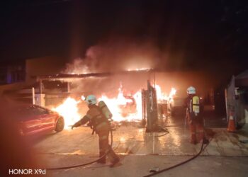 ANGGOTA Jabatan Bomba dan Penyelamat Malaysia (JBPM) dalam operasi memadamkan kebakaran melibatkan dua buah rumah teres malam tadi. - ihsan JBPM