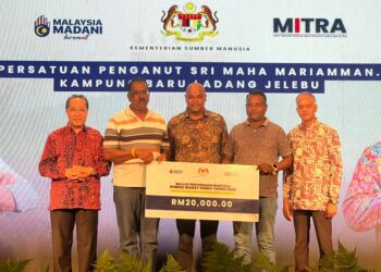 RAMANAN (tengah) menyampaikan sumbangan berjumlah RM20,000 kepada salah sebuah kuil yang menerima manfaat di bawah Program Dharma Madani Fasa Kedua di Dewan Kaladamaphan, di sini, hari ini.