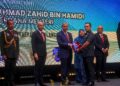 AHMAD Zahid Hamidi menyampaikan Anugerah Kecemerlangan Penguatkuasaan kepada Mohamad Ashradd Azhari pada Majlis Sambutan Hari Penguat Kuasa KPDN dan Pelancaran Dasar Pengguna Negara 2.0 di Cyberjaya. - UTUSAN/FAISOL MUSTAFA