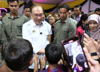 ANWAR Ibrahim beramah mesra bersama pengunjung pada Program Madani Rakyat (PMR) negeri Perak di Ipoh hari ini. - UTUSAN/ZULFACHRI ZULKIFLI