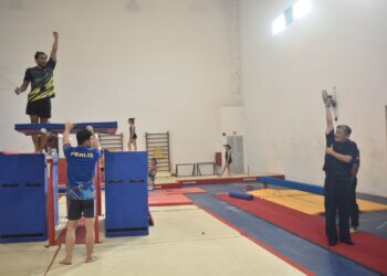 KAU Git Kaur (kanan) memberi tunjuk ajar kepada atlet negeri ini semasa turun padang di Dewan Gimnastik Artistik SK Sena, Kangar, Perlis. -UTUSAN/ASYRAF MUHAMMAD