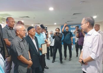 FAHMI  Fadzil (kanan) beramah mesra dengan Pengerusi Panel Penasihat  Pusat Sebaran Maklumat Nasional (NADI)  pada majlis penyerahan watikah pelantikan di Terengganu.- UTUSAN/ERMA YUSNIDA JUSOH