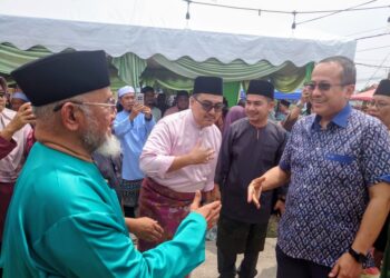 DR. Mahfodz Mohamed (kiri) menyambut ketibaan Ahmad Samsuri Mokhtar pada majlis Rumah Terbuka Aidilfitri PAS Negeri Johor di Bukit Pasir, Pagoh, Muar.