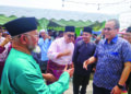 MAHFODZ Mohamed (kiri) menyambut ketibaan Ahmad Samsuri Mokhtar pada majlis Rumah Terbuka Aidilfitri Pas Negeri Johor di Bukit Pasir, Pagoh, Muar.