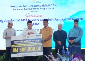 SIRAJUDDIN Suhaimee (dua dari kiri) menyampaikan cek cura sebagai simbolik penyaluran peruntukan kepada wakil Kampung Buaya sebagai Kampung Angkat Madani Jakim di Padang Rengas, Perak hari ini. - UTUSAN/FADZIL ZAINOL
