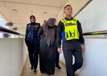 SITI Hajartul Haini Abd Hamid (tengah) dibawa anggota polis selepas tidak mengaku bersalah lapan pertuduhan menipu berkaitan emas di Mahkamah Sesyen Alor Setar, hari ini.