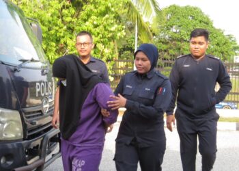 SEORANG wanita dibawa oleh anggota polis untuk prosiding tahanan reman di Mahkamah Gua Musang, Kelantan.