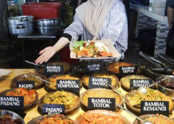 NTAN Surina Alias menunjukkan pelbagai jenis sambal yang dijual di kedainya. – MINGGUAN/PUQTRA HAIRRY