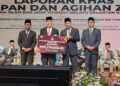 TENGKU Mohd. Rizam Tengku Abdul Aziz (dua dari kiri) menyempurnakan penyerahan bantuan rumah kediaman MAIK Tahun 2026 kepada ketua-ketua jajahan pada Majlis Sidang Akhbar Laporan Khas Kutipan dan Agihan Zakat Maik Bagi Tahun 2025 di Kota Bharu, Kelantan. - UTUSAN/MUSTAQIM MOHAMED