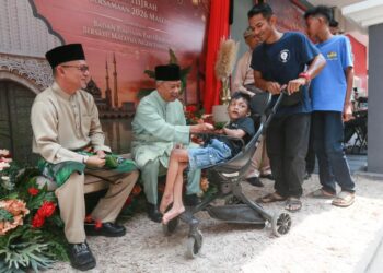 MUHYIDDIN Yassin (dua dari kiri) menyampaikan sumbangan duit raya kepada kanak-kanak semasa hadir pada Majlis Jamuan Raya Bersatu Terengganu di Batu Buruk, Kuala Terengganu, Terengganu. - UTUSAN/PUQTRA HAIRRY