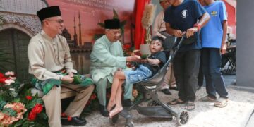 MUHYIDDIN Yassin (dua dari kiri) menyampaikan sumbangan duit raya kepada kanak-kanak semasa hadir pada Majlis Jamuan Raya Bersatu Terengganu di Batu Buruk, Kuala Terengganu, Terengganu. - UTUSAN/PUQTRA HAIRRY